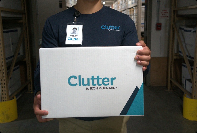 Clutter team member holding a Clutter by Iron Mountain box in a secure warehouse